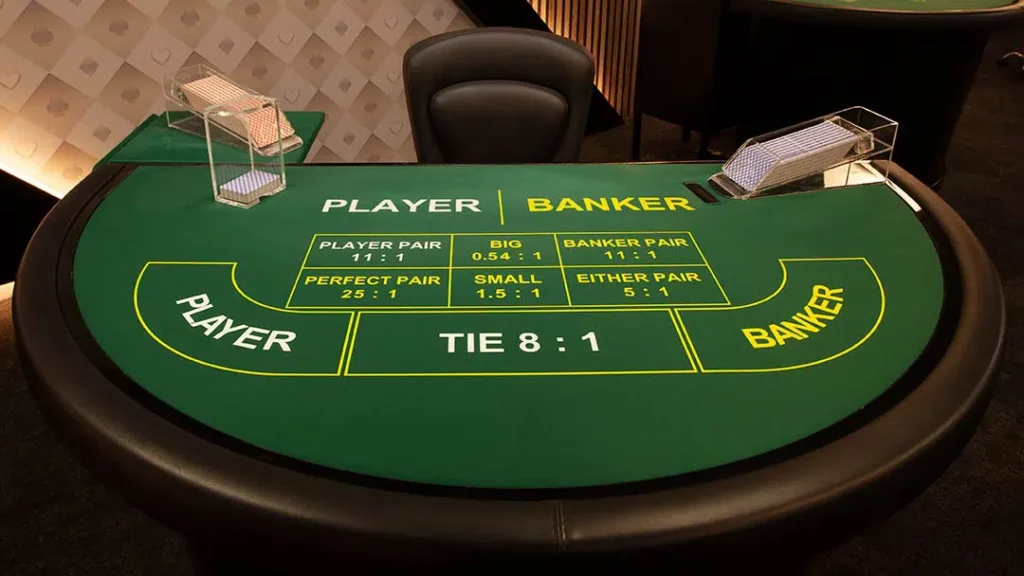 Empty live baccarat table with marked betting areas for player, banker, tie, and side bets.