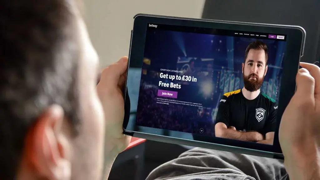 Man using tablet to browse Betway betting site welcome offer of £30 in free bets.sam