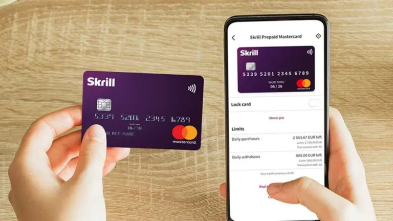 Skrill prepaid Mastercard held in hand next to smartphone showing Skrill app with card details and limits.